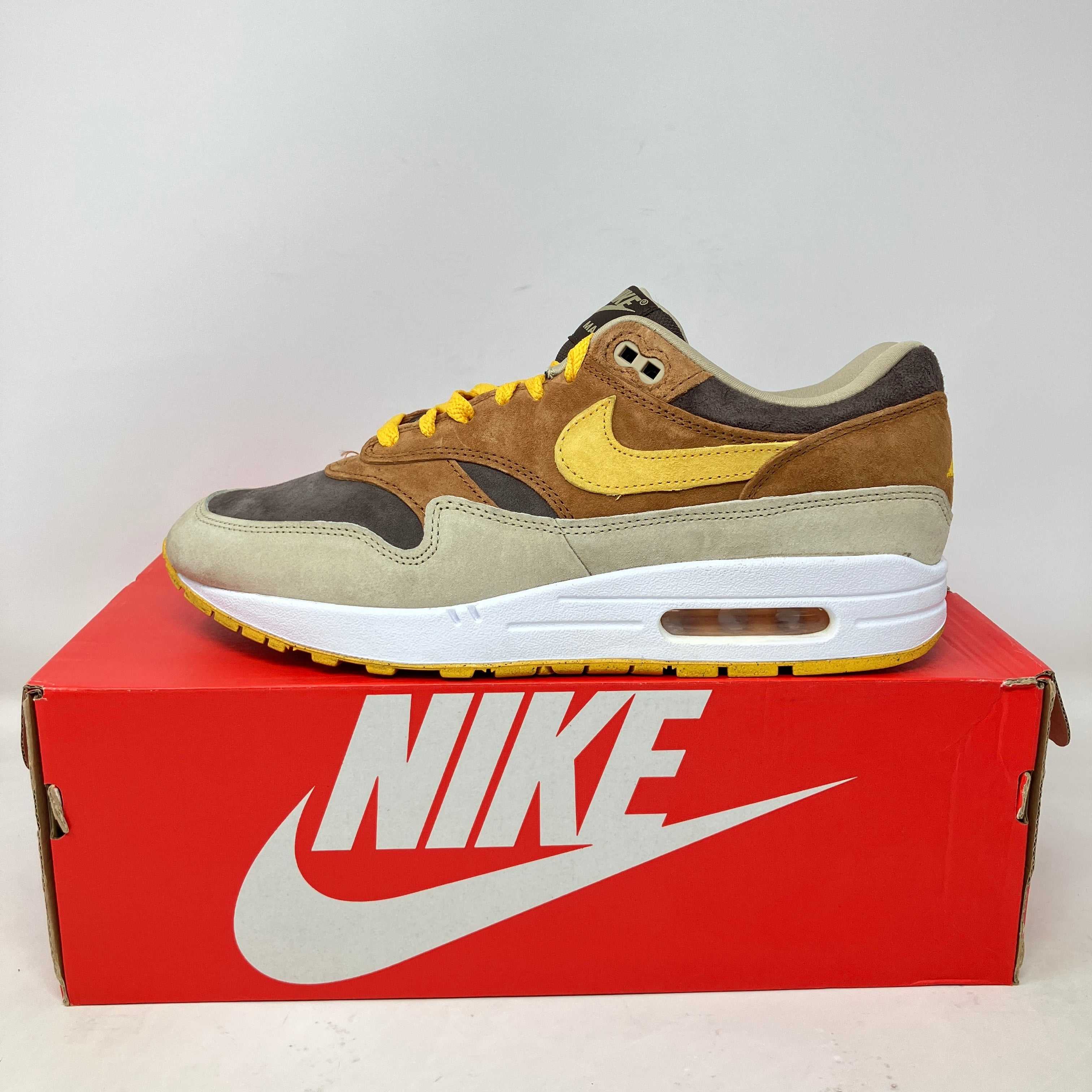 Nike Air Max 1 PRM Duck Pecan Yellow Ochre sneaker on red Nike box, pre-owned with all accessories included