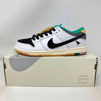 Nike SB Dunk Low sneaker in white leather with black suede toe and swoosh, teal collar, yellow accents, and multicolor outsole