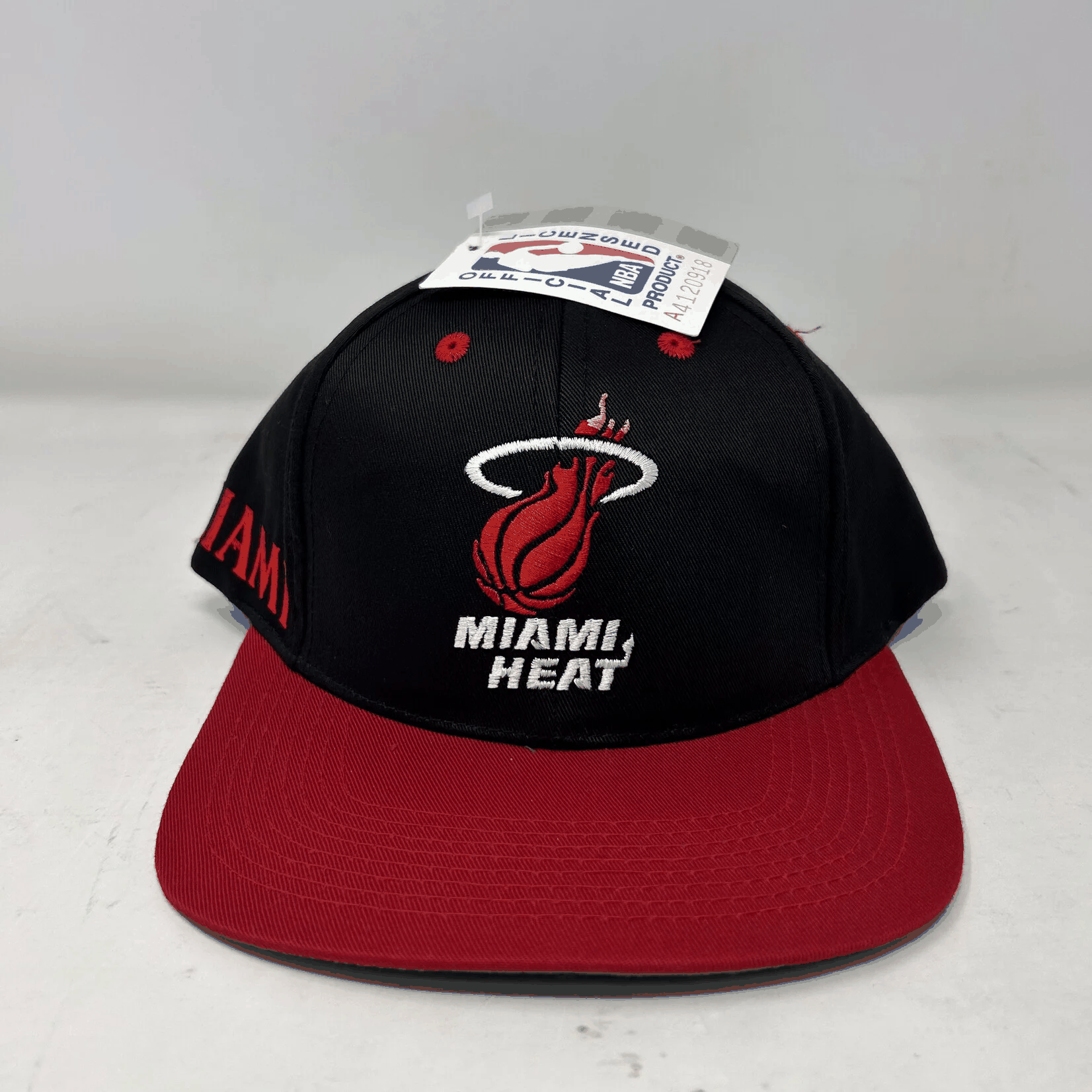 Vintage Miami Heat snapback hat with black crown and red brim, brand new condition with all accessories included.