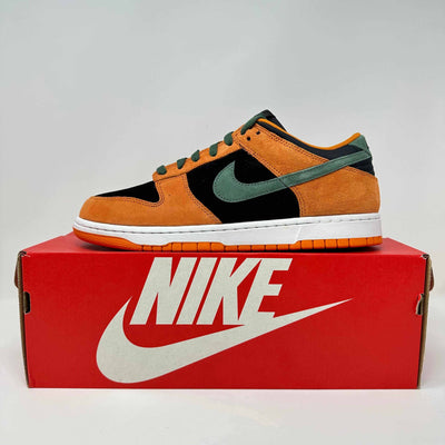 Nike Dunk Low sneaker in orange suede with black panels, teal leather Swoosh and accents, and a white midsole.