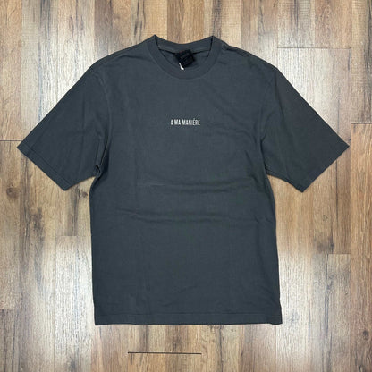 Jordan x A Ma Maniere grey T-shirt with small white logo, pre-owned, laid flat on wooden floor