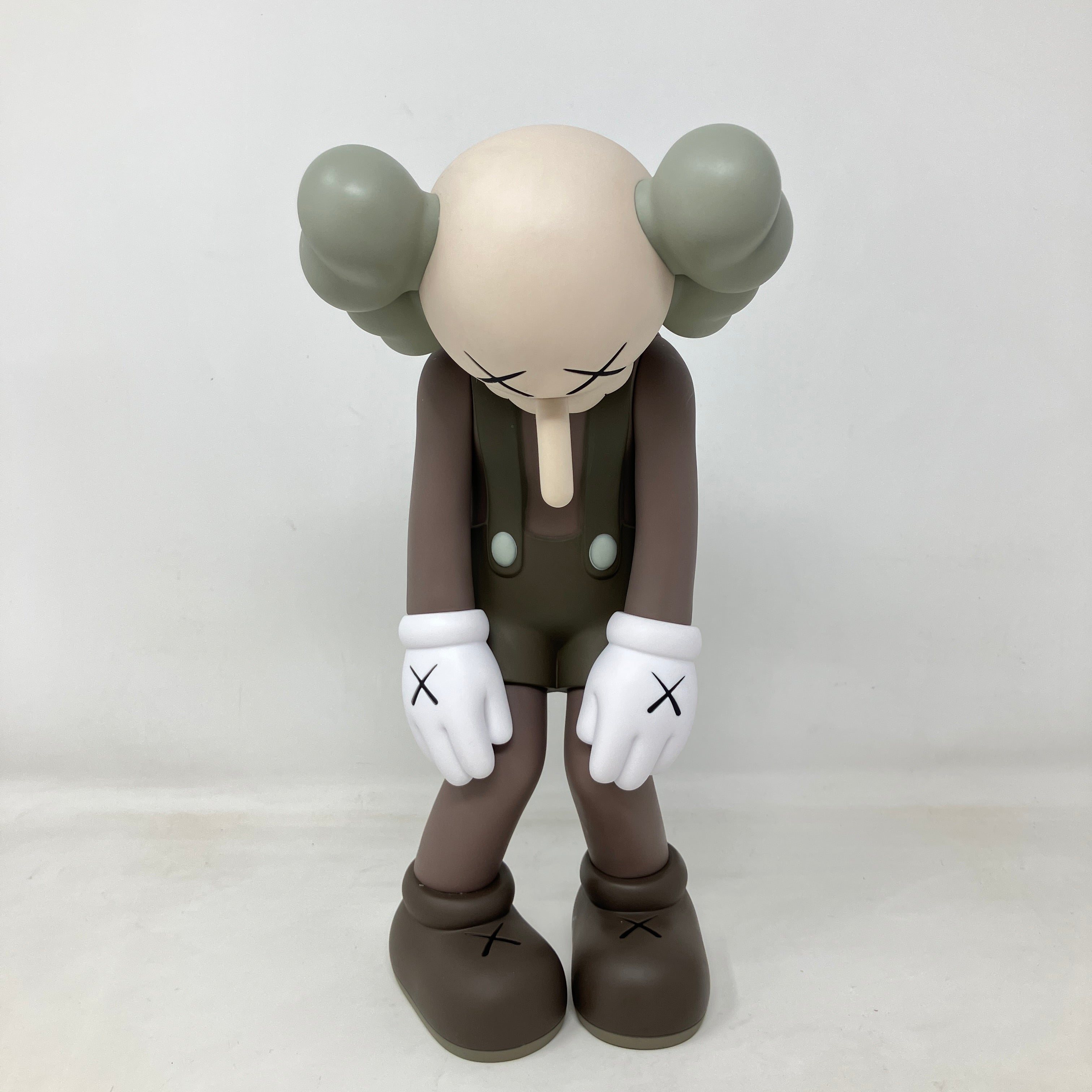 KAWS Small Lie Companion grey vinyl figure standing with head bowed and hands forward, brand new with accessories included.