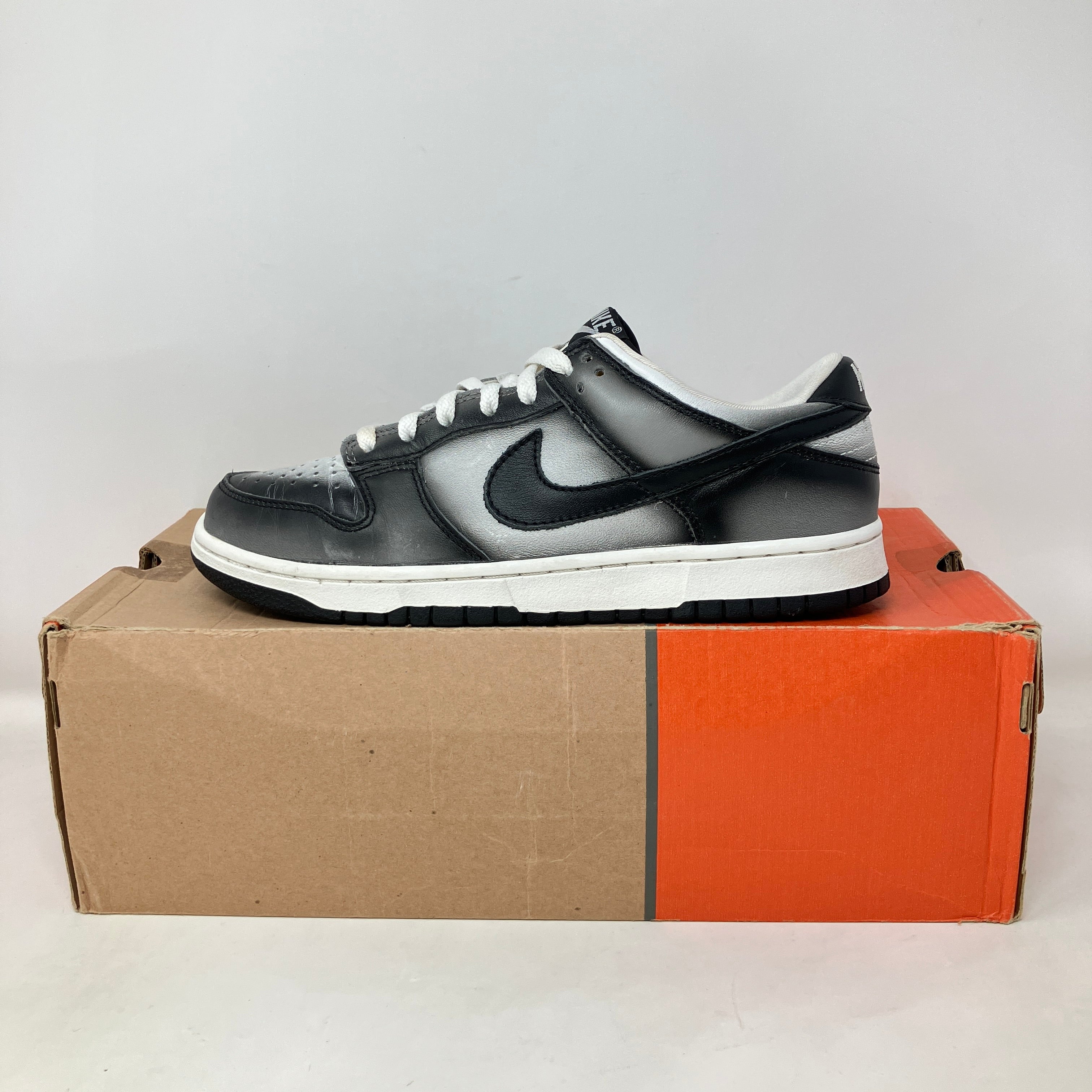 Nike Dunk Low Haze black and gray sneaker pre-owned with some separation on an orange and brown shoebox