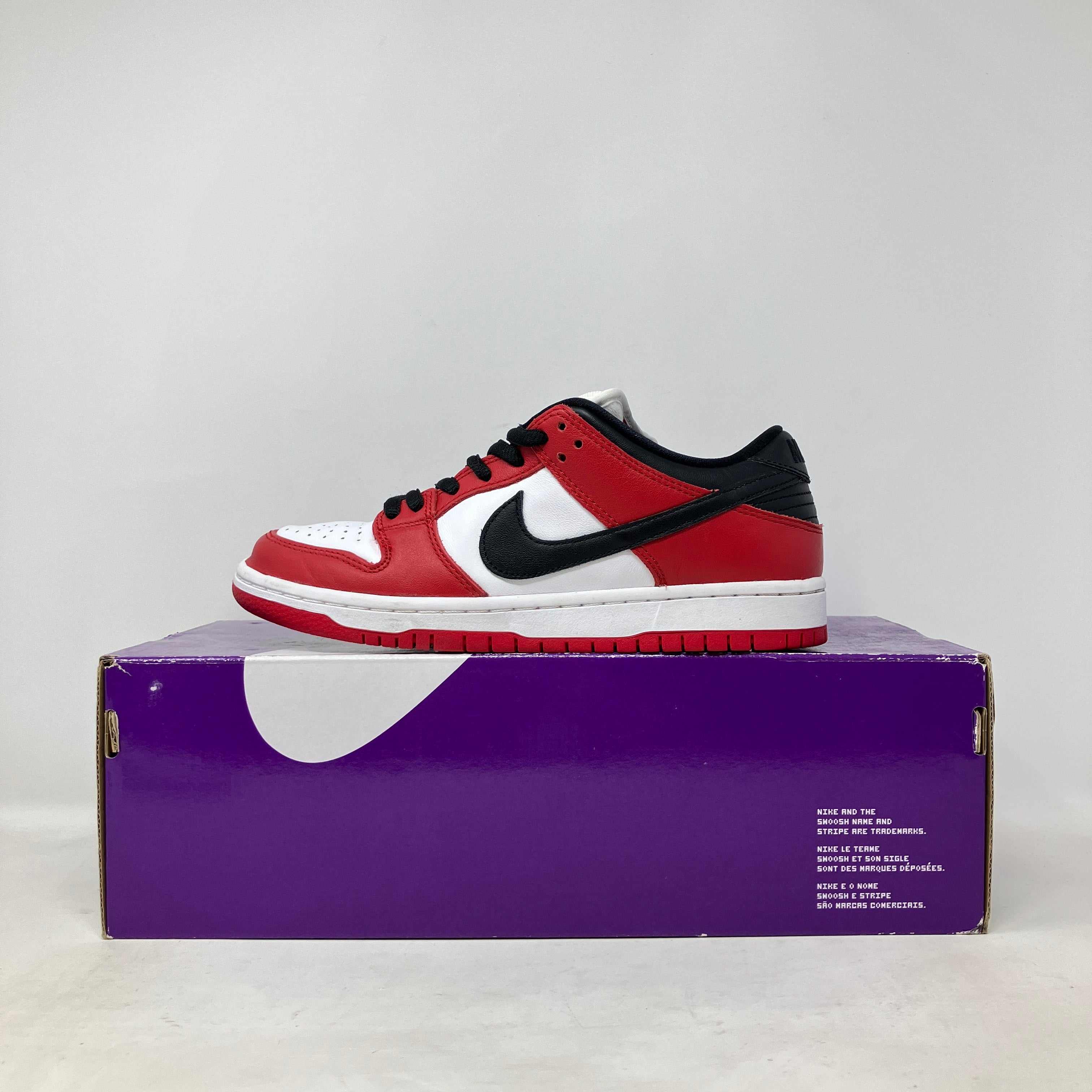 Nike SB Dunk Low Pro J-Pack Chicago sneaker in red, white, and black on purple Nike box, pre-owned with accessories included