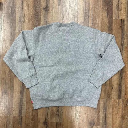 Heather grey Supreme Box Logo crewneck sweatshirt, brand new condition, on wooden floor background.