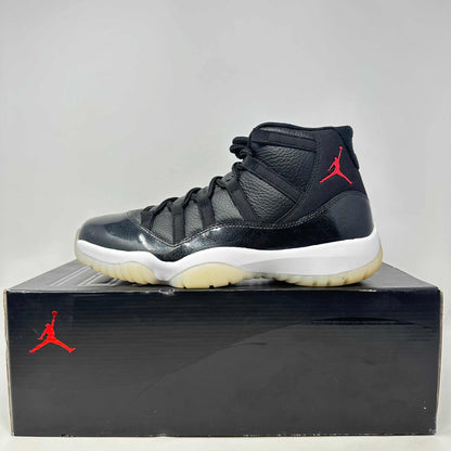 Jordan 11 Retro 72-10 black sneaker with red Jumpman logo on box and shoe, brand new condition with all accessories.