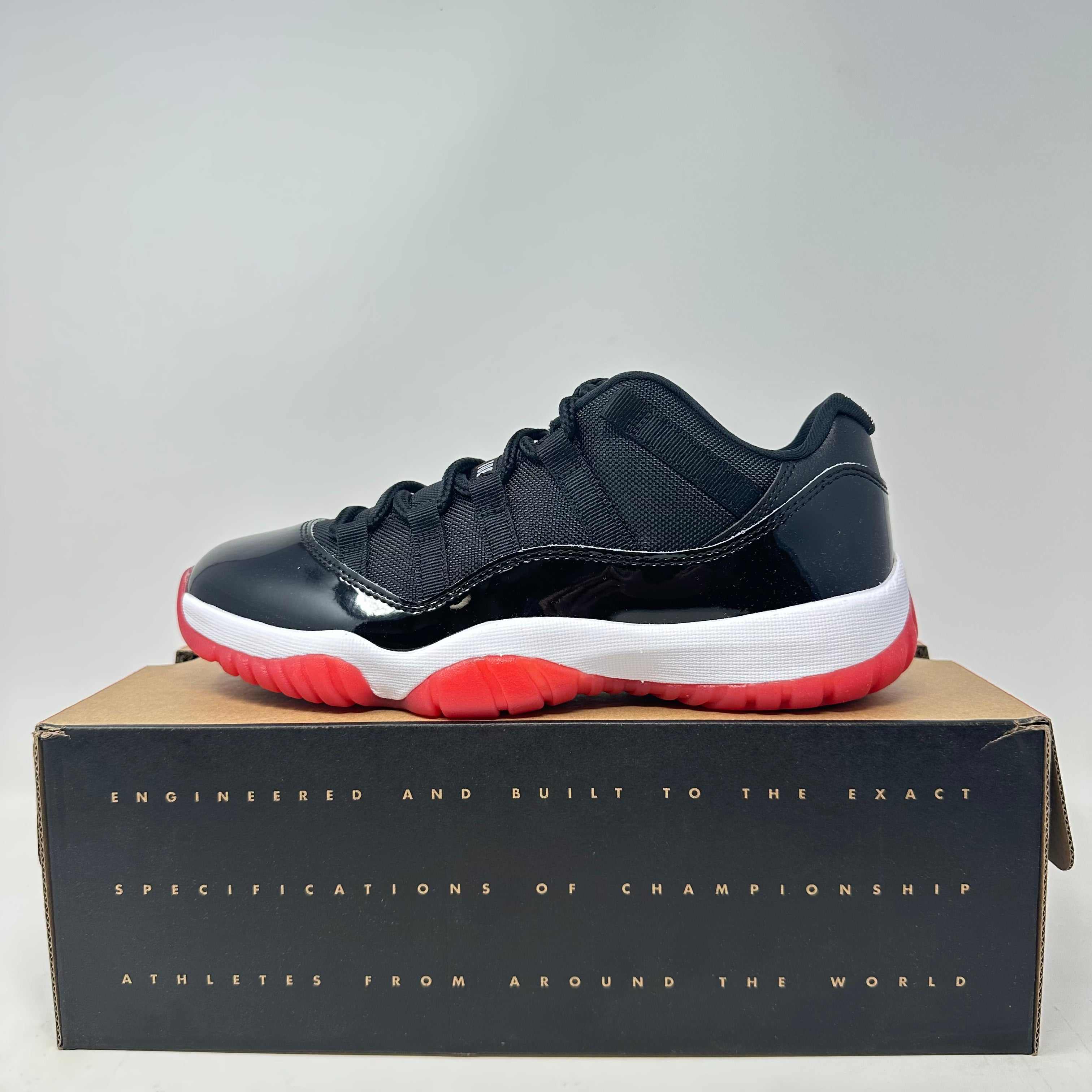 Jordan 11 Retro Low Bred 2025 sneaker in black and red on the shoebox, brand new condition with all accessories included