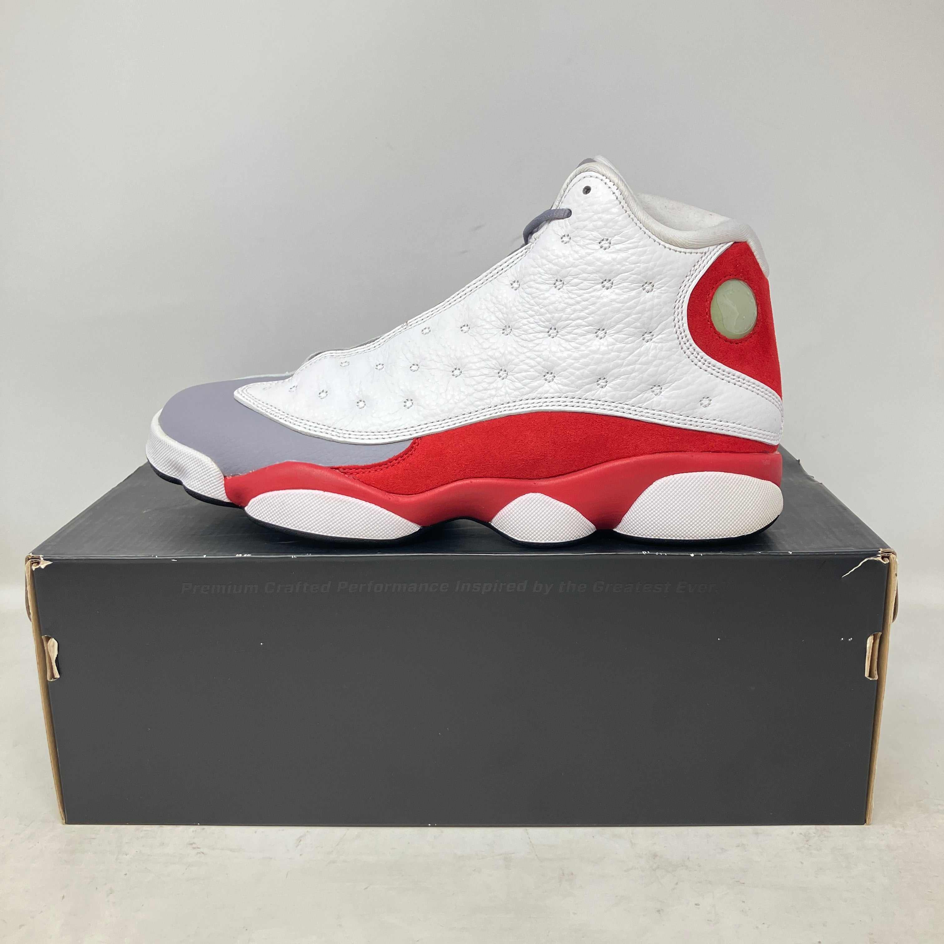 Jordan 13 Retro Grey Toe 2014 sneaker in white, red, and grey on black shoebox, pre-owned condition with accessories included