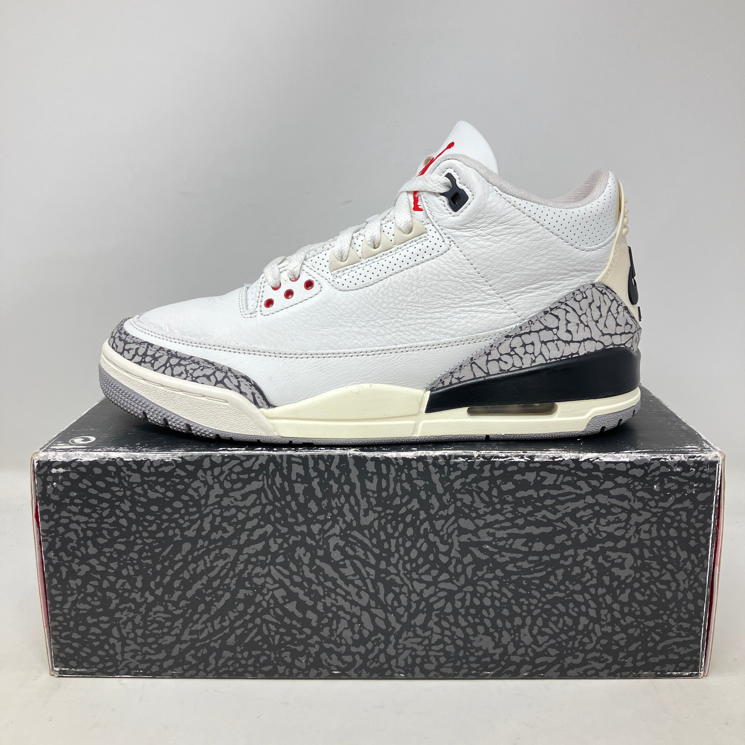 Jordan 3 Retro White Cement Reimagined sneakers pre-owned with accessories, displayed on box.