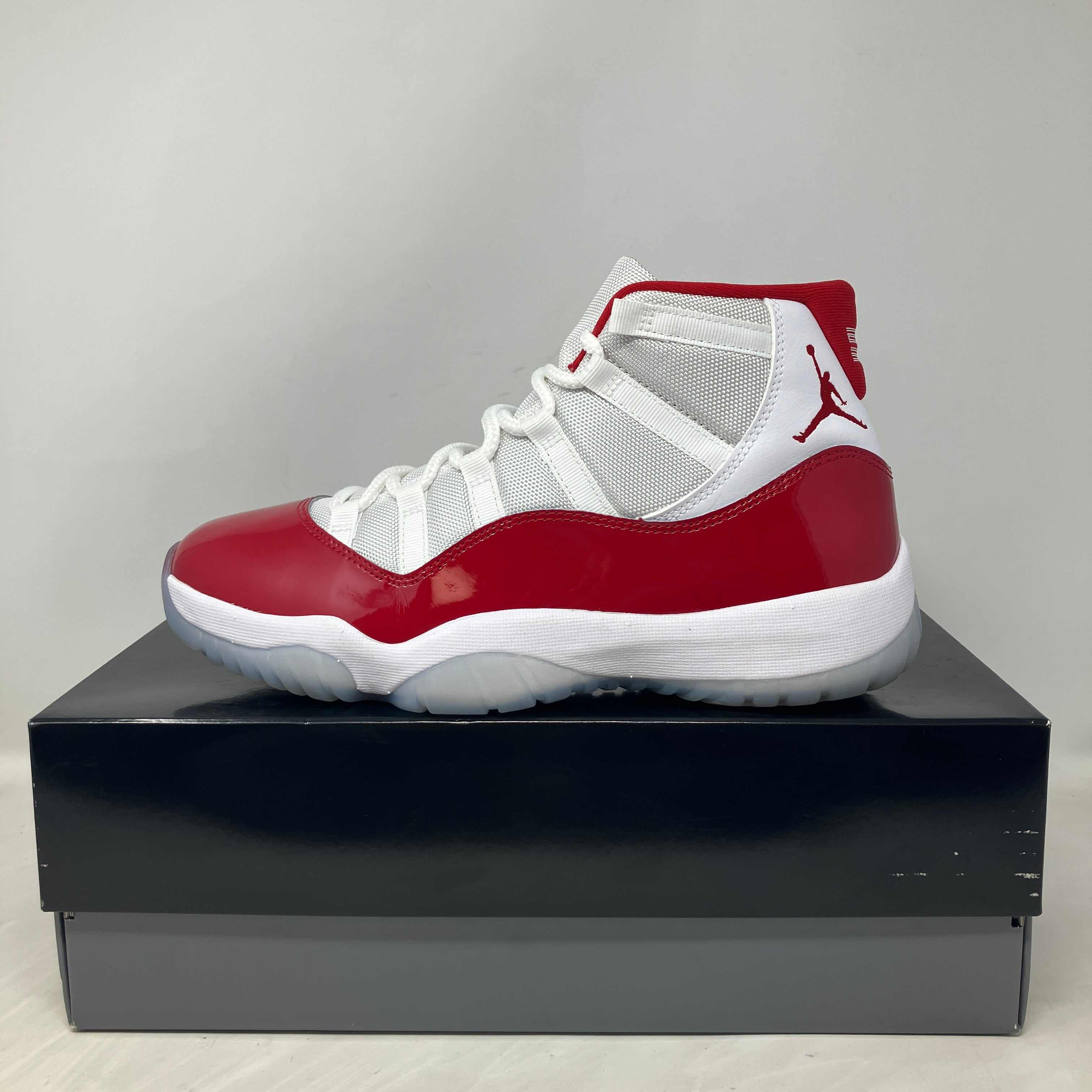 Jordan 11 Retro Cherry 2022 sneaker in white and red with accessories on box