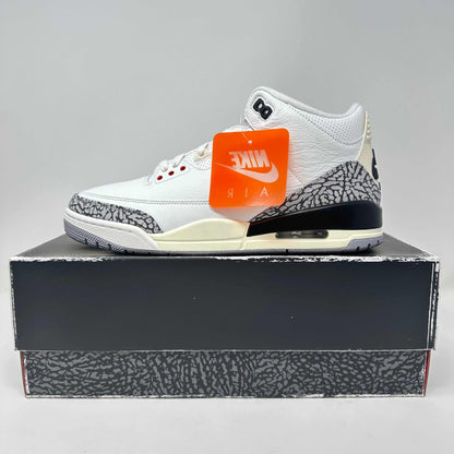 White Jordan 3 Retro sneaker with cement print on a matching box and Nike Air tag