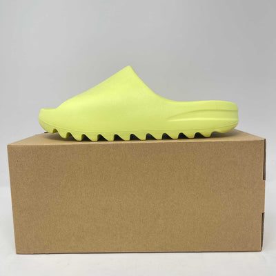 adidas Yeezy Slide in bright glow green foam with a smooth, sculpted open-toe design and ridged sole.