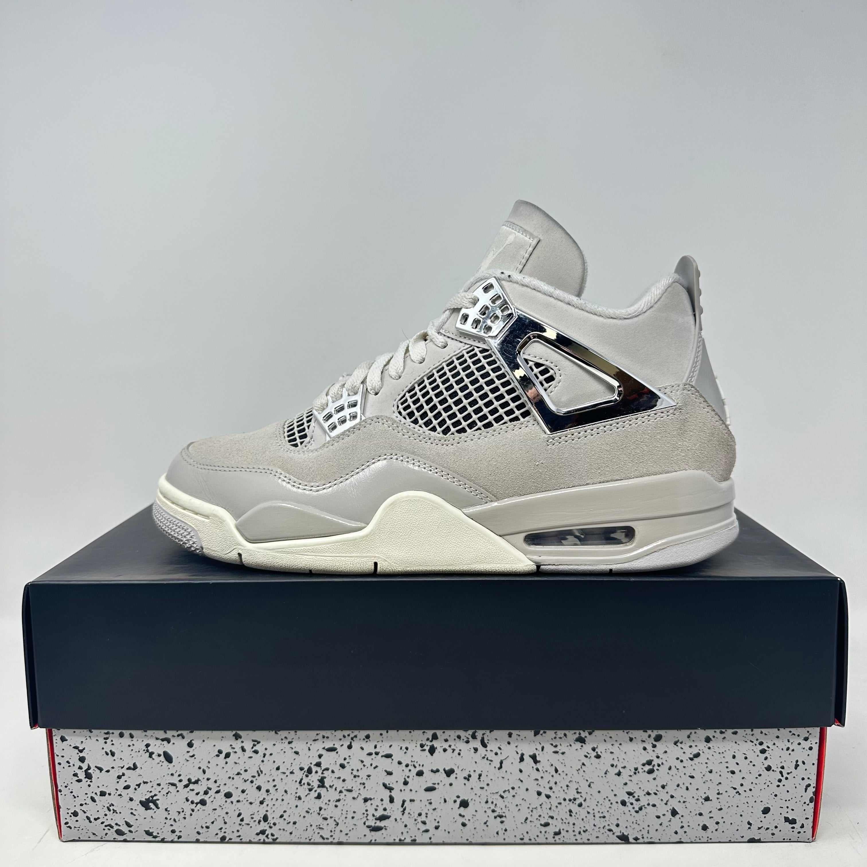 Jordan 4 Retro Frozen Moments sneaker in light grey with chrome accents on box