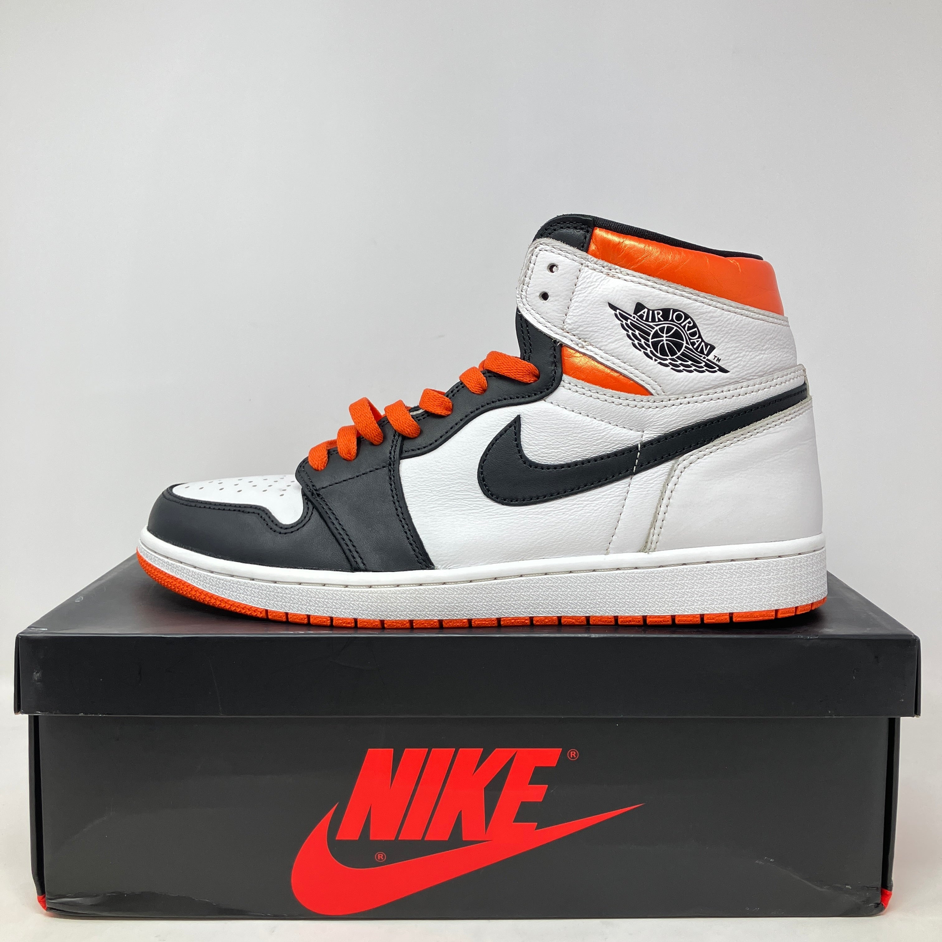 Jordan 1 Retro High Electro Orange sneaker in white, black, and bright orange on black Nike box