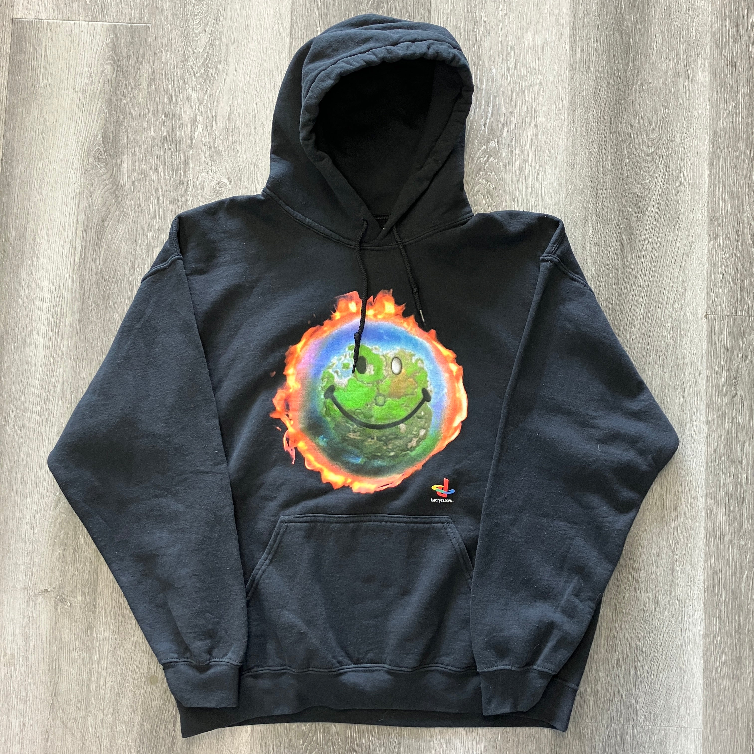 Black Cactus Jack by Travis Scott x PlayStation World hoodie with flaming smiley earth graphic and front pocket