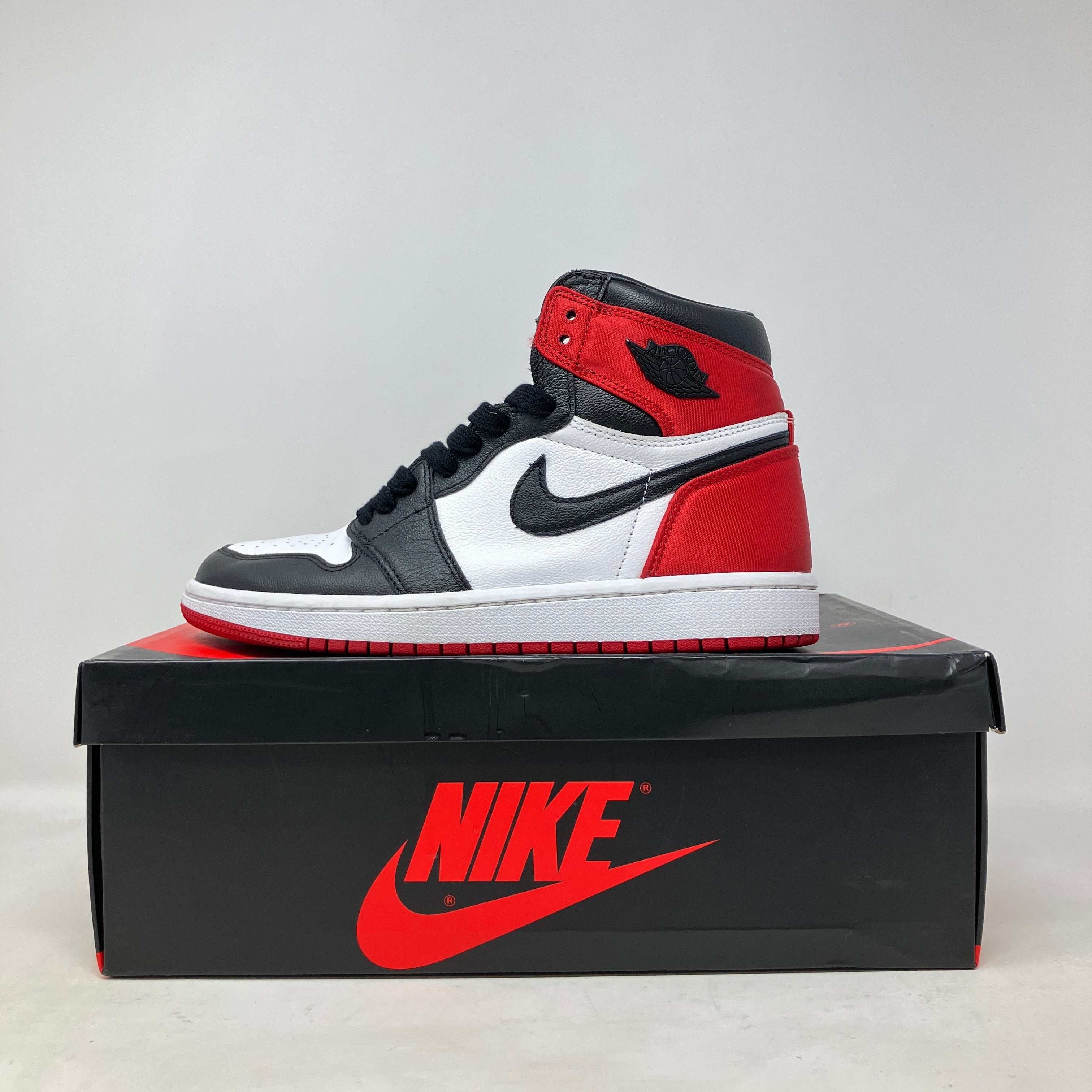 Jordan 1 Retro High Satin Black Toe women's sneaker in black, white, and red on Nike box, pre-owned with accessories included.
