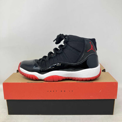 Jordan 11 Retro Playoffs Bred 2019 GS sneaker in black and red on Nike box