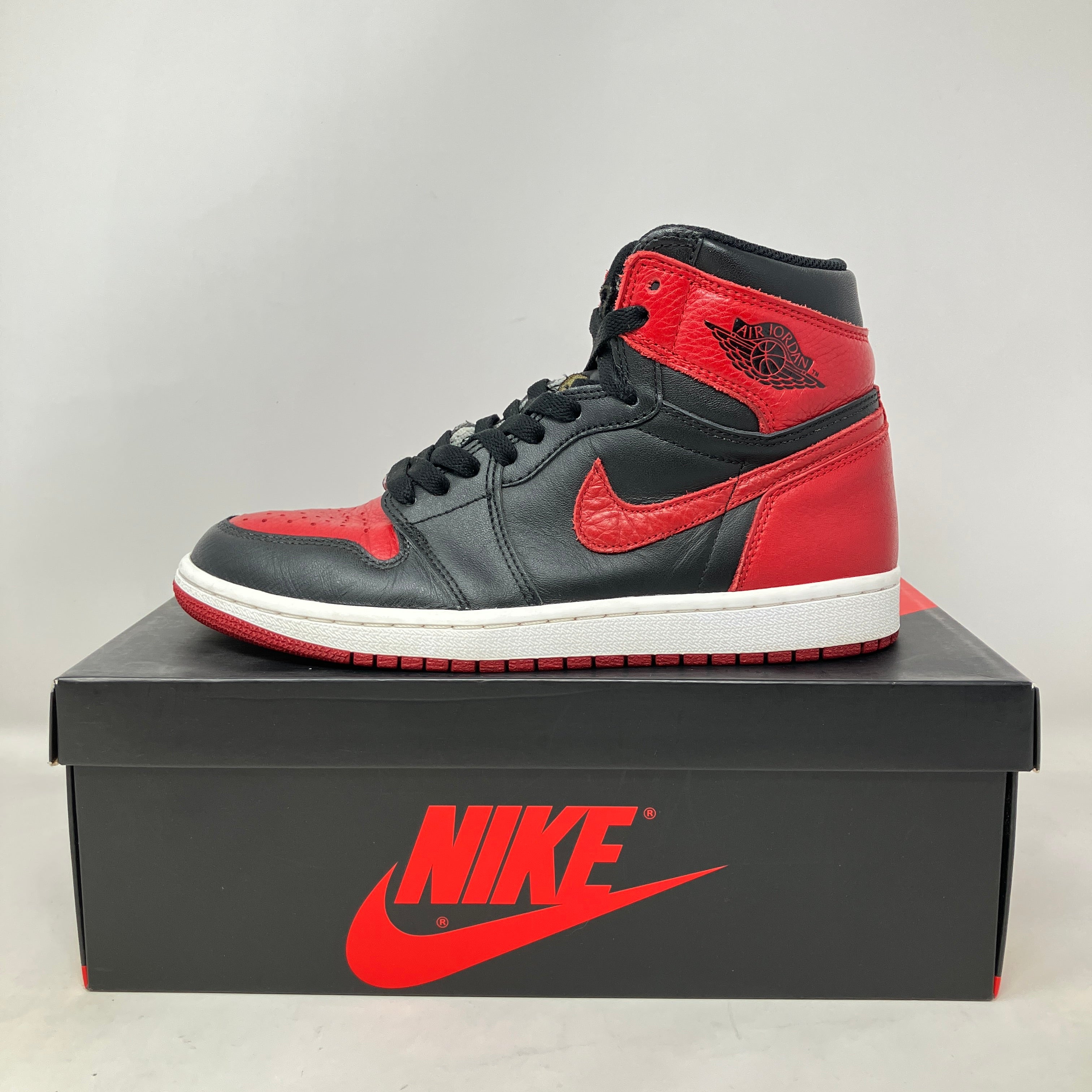 Jordan 1 Retro High Bred Banned 2016 sneaker in black and red on Nike box, pre-owned with accessories included