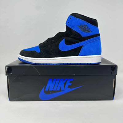 Jordan 1 high-top sneaker in black and royal blue leather with a white midsole, blue Swoosh, and ankle wings logo.