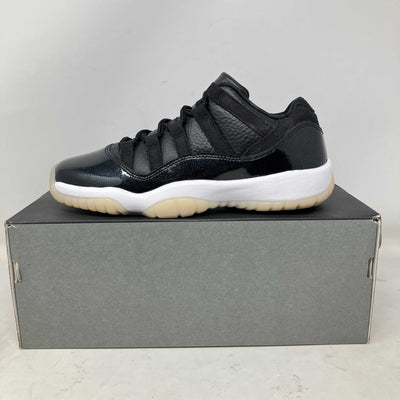 Jordan 11 Retro Low sneaker in black leather and mesh, with glossy patent panels, a white midsole, and translucent outsole.