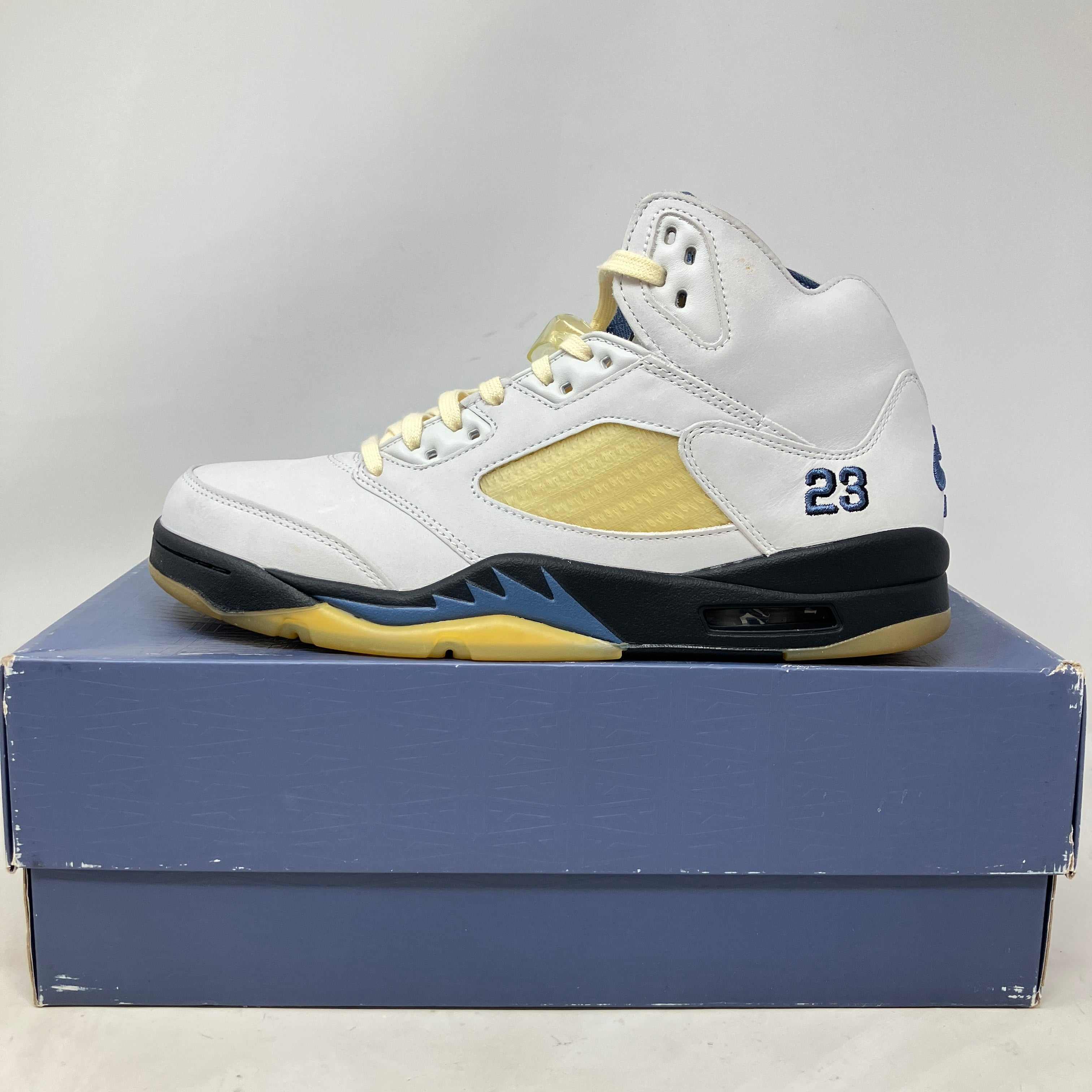 White and navy Jordan 5 Retro A Ma Maniére Dawn women's sneaker on blue box