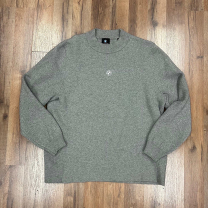 Kith x BMW knit mockneck sweater in heather grey laid flat on wooden floor