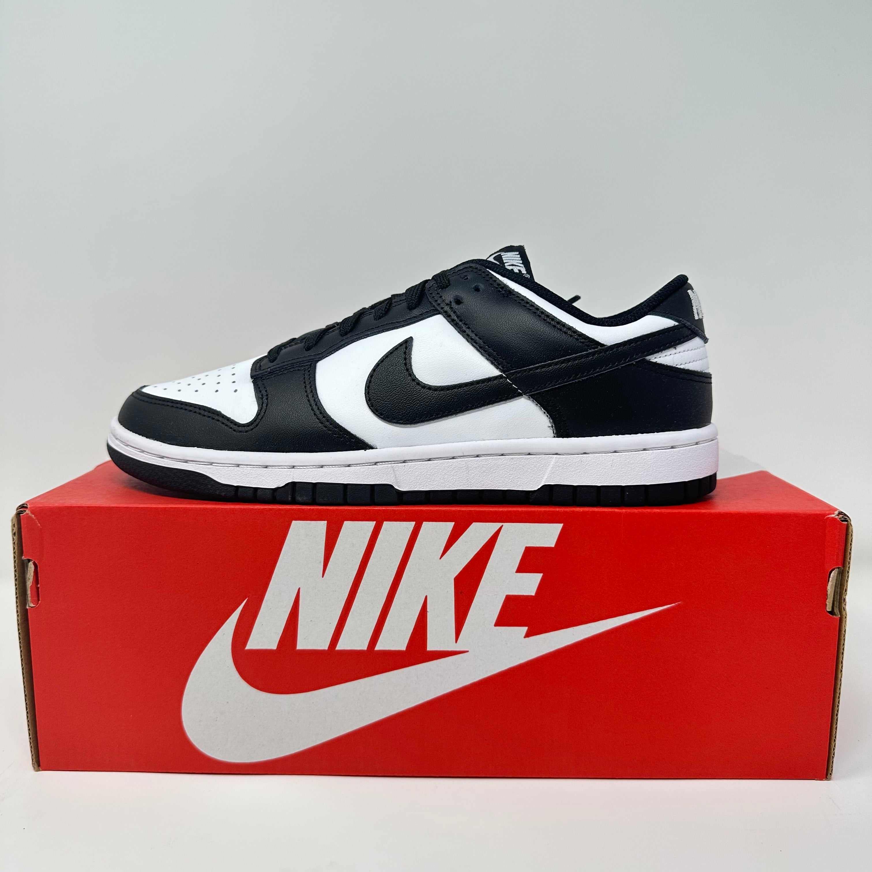 Nike Dunk Low Retro White Black Panda sneaker on red Nike shoebox, brand new condition with all accessories included