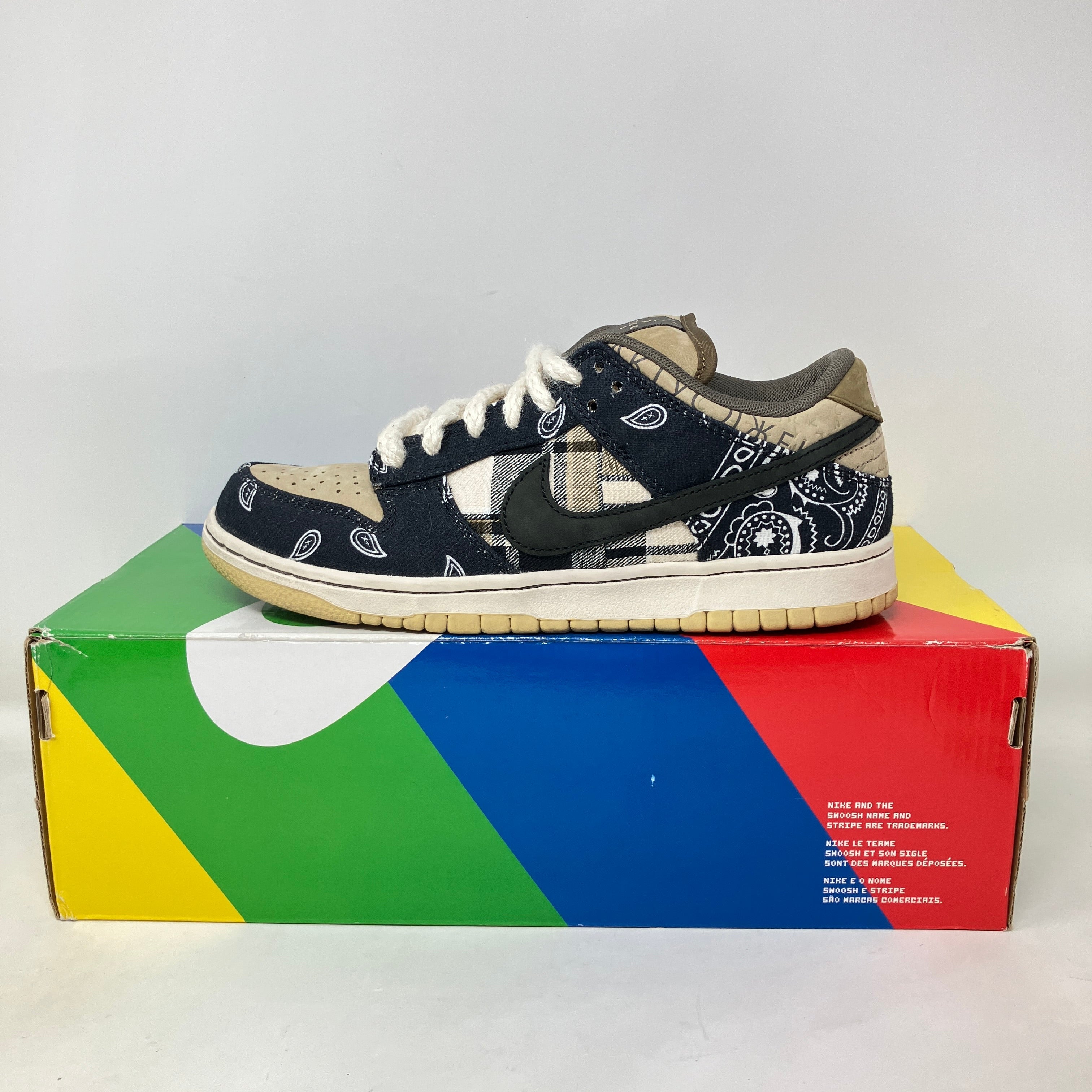 Nike SB Dunk Low Travis Scott sneaker with bandana print pattern on colorful shoe box